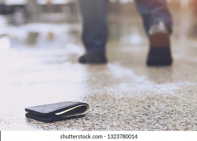 businessman had lost leather wallet with money on the street. Close-up of wallet lying on the sidewalk in during the trip to work.