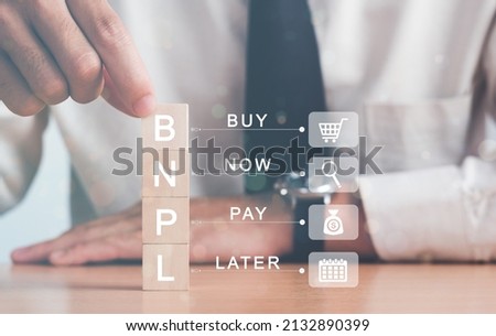 Businessman hand arranging wood block with icon BNPL with online shopping icons. Buy now pay later online shopping concept.