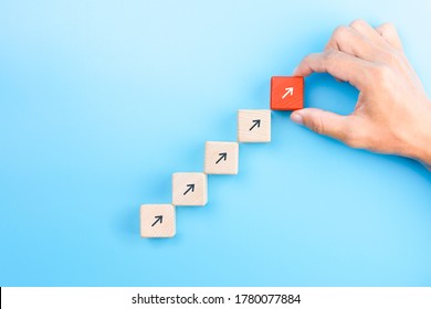 Businessman hand arranging wooden blocks stacking as step stair with arrow up, Business growth success process concept, copy space