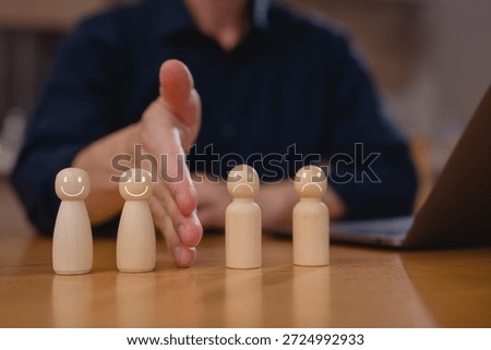 Businessman hand blocking and divide between group of wooden figure for resolving conflict and mediate management concept.