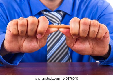 Businessman hand breaking yellow pencil. - Powered by Shutterstock