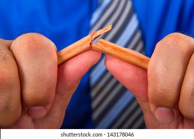 Businessman hand breaking yellow pencil. - Powered by Shutterstock