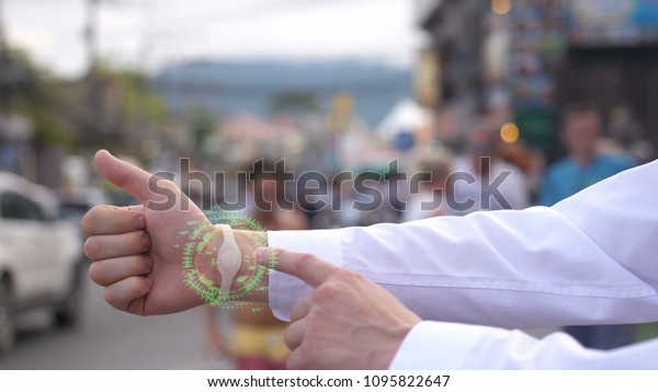 A businessman hand call a friend\
wearing hologram futuristic clock. Augmented\
reality.