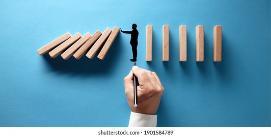 Businessman Hand Drawing Silhouette Of A Man Making A Stop Gesture To Prevent Wooden Dominos From Collapsing On Blue Background.