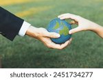 Businessman hand giving Earth globe to little boy as Earth day concept as corporate social responsible to contribute greener environmental protection for sustainable future generation. Gyre