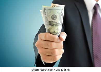 Businessman hand grabbing money, US dollar (USD) bills