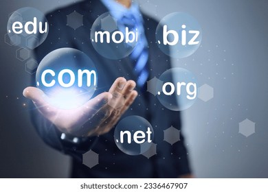 Businessman hand holding and choosen bubble sub domain name to dot com or .com to registeration the commercial website. Domain selection concept.