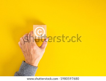 Businessman hand holding a copyright symbol. Property rights and brand patent protection in business concept.