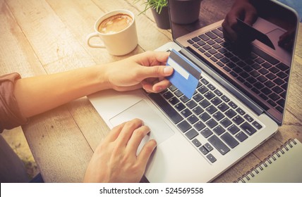 Businessman Hand Holding Credit Card And Use Laptop Vintage Tone.