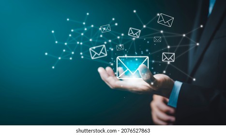 Businessman hand holding e-mail icon letter on a touch screen interface, virtual postal envelope, concept of spam email, internet and networking, Contact us newsletter email and protect your personal. - Shutterstock ID 2076527863