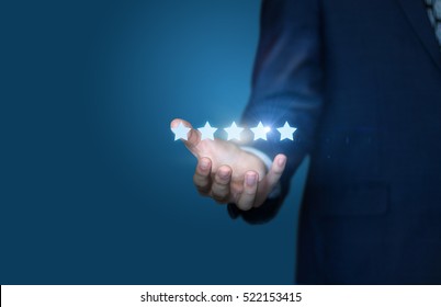 Businessman hand holding five stars isolated on blue background.