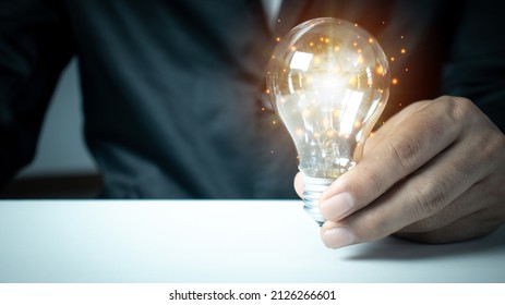 businessman hand holding light bulb with finance document and tool, concept of New ideas for business and finance.  - Shutterstock ID 2126266601