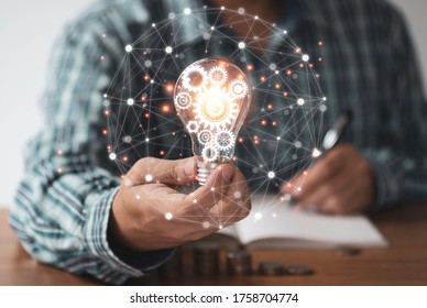 Businessman hand holding lightbulb with orange glowing and connection line. Creative thinking idea concept. - Shutterstock ID 1758704774