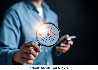 Businessman hand holding Magnifier glass focus to target icon which for planning development leadership and customer target group concept. - Shutterstock ID 2268144279