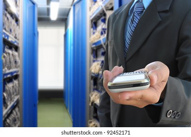 businessman hand holding mobile phone in the communication and internet network server room - Powered by Shutterstock