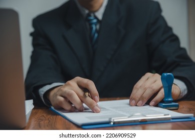 Businessman hand holding pen paperwork chart report and document financial graph investment marketing or tax insurance on desk. - Shutterstock ID 2206909529