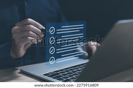 Businessman hand holding a pen ticking a red checkmark on a box in the list Show on the virtual screen. Checklist Ideas in Business Survey items and questionnaires. copy space