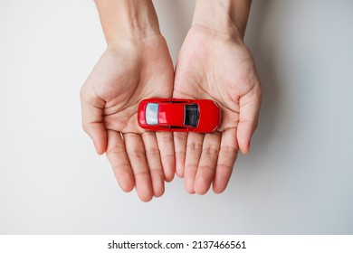 Businessman Hand Holding Red Car Toy. Car Insurance, Warranty, Rental, Financial, New And Repair Concept