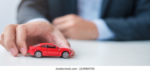 Businessman Hand Holding Red Car Toy. Car Insurance, Warranty, Rental, Financial, New And Repair Concept