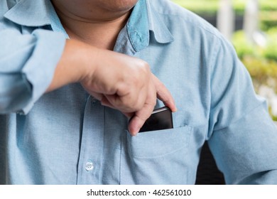 Businessman Hand Holding Smart Phone In Shirt Pocket