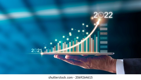 Businessman hand holding tablet showing graph economic growth target success from 2021 to 2022. Plans to increase business growth and Analysis strategy. Plan business growth in year 2022 concept. - Shutterstock ID 2069264615