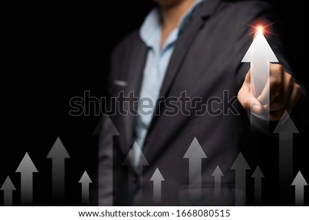 Businessman hand point to up or increase arrow black background. It is symbol of business investment growth concept.
