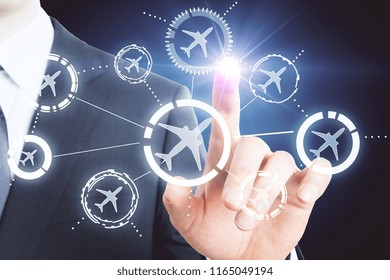 Businessman hand pointing at creative glowing airplane interface. Travel and hud concept - Shutterstock ID 1165049194