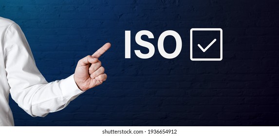 Businessman hand points to the word ISO with check tick icon. Meeting iso standards in corporate business concept.