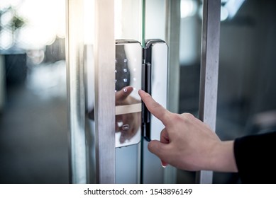 Businessman hand pressing down password number on electronic access control machine to open the office door. Security system concept