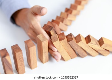 businessman hand protect wooden toy block from danger and fall, insurance - Shutterstock ID 1055532317