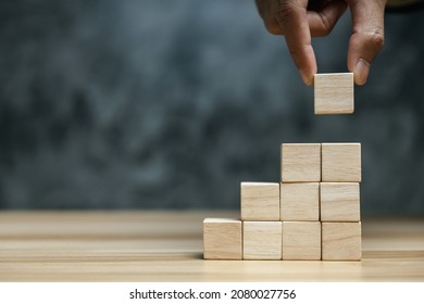 Businessman Hand Putting Blank Wooden Cube Block Stack On Dark Background With Copy Space For Input Text, Icon, Trend, Creative Idea, Finance, Leadership, Strategy, Business, Online Marketing Concept