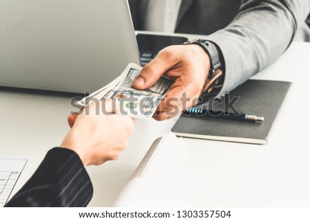 Businessman hand sending money to another business person. Transaction, payment, salary and banking concept.