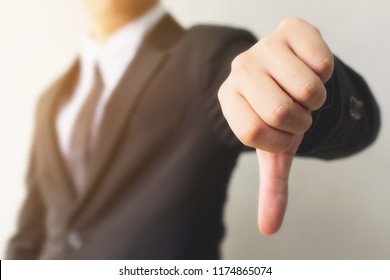 Businessman hand showing thumb down sign gesture. Dislike or bad concept