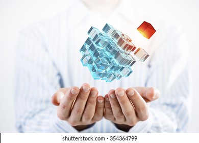 Businessman hand shows cube as symbol of problem solving 
