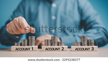 Businessman hand stacking coins idea of financial investment management by portfolio diversification for distributing risks and increasing opportunities. Concepts for Savings investment and expenses.