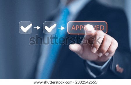 A businessman Hand Stamping With Approved Stamp On Document. Business process workflow illustrating management approval, flowchart with businessman in background