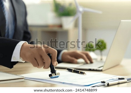 Businessman Hand Stamping With Approved Stamp On Document At Desk. validates and manages business documents and agreements, and approves business cooperation to comply with environmental laws. ESG
