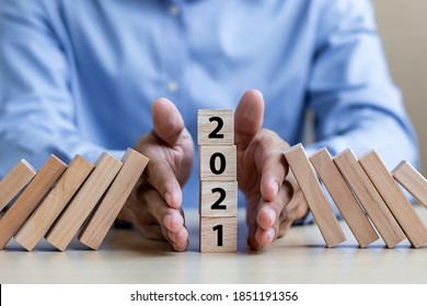 Businessman Hand Stopping Falling Of 2021 Wooden Blocks. Business, Risk Management, Insurance, Resolution, Strategy, Solution, Goal, New Year New You And Happy Holiday Concepts