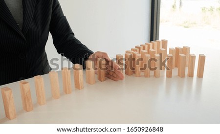 Businessman hand Stopping Falling wooden Blocks or Dominoes. Business, Risk Management, Solution, Insurance and strategy Concepts. 