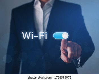 Businessman hand switch on Wi-Fi button.
Wi-Fi wireless concept. Free WiFi network signal technology internet concept.