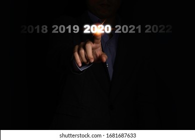 Businessman Hand Touching 2020 Year On Black Background. It Is Symbol Of Fiscal And Business Year Change.