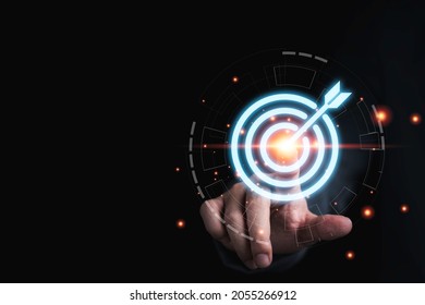 Businessman hand touching to target dart board for setup and achievement objectives target for business investment concept. - Shutterstock ID 2055266912