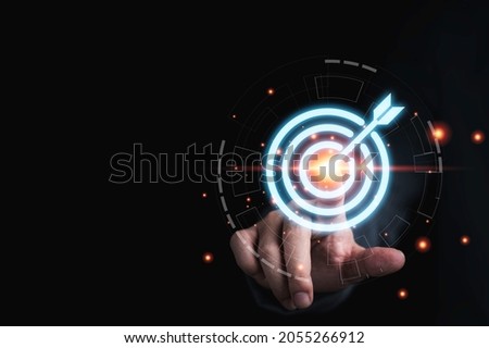 Businessman hand touching to target dart board for setup and achievement objectives target for business investment concept.