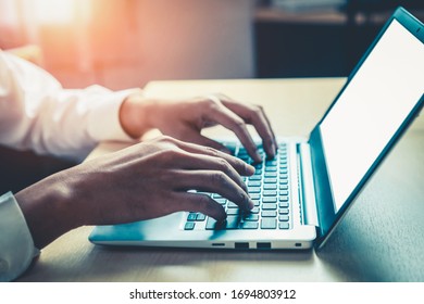 Businessman hand typing on computer keyboard of a laptop computer in office. Business and finance concept. - Shutterstock ID 1694803912