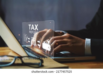 Businessman hand using a laptop with bar  TAX REFUND and refund tax of duty taxation business, tax form, and wallet money being demonstrated on the screen media, online for tax payment. - Shutterstock ID 2177457525