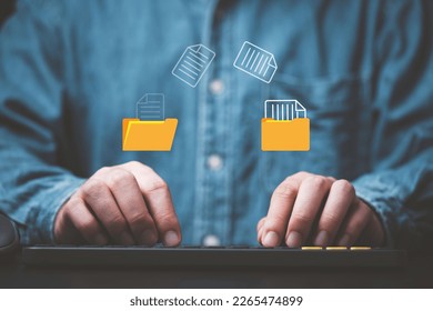 Businessman hand using laptop computer with data folder file icon for information exchange and transfer concept. - Powered by Shutterstock