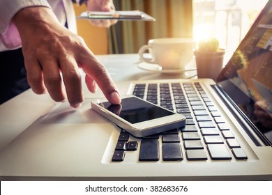 Businessman Hand Using Laptop And Smart Phone In Office Morning Light