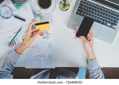 Businessman Hand Using Laptop,mobile Payments Online Shopping With Computer In Modern Office On Wooden Desk.Top View