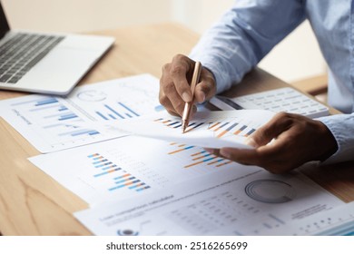 Businessman hand using pen, notebook and desktop summarizing company profit with success graph, checking quarterly report results. - Powered by Shutterstock