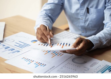 Businessman hand using pen, notebook and desktop summarizing company profit with success graph, checking quarterly report results. - Powered by Shutterstock